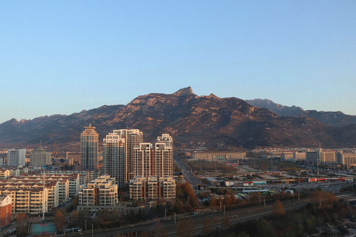 2020年12月8日,山东泰安,凌晨,火红的太阳冉冉升起.城市在日出的照耀