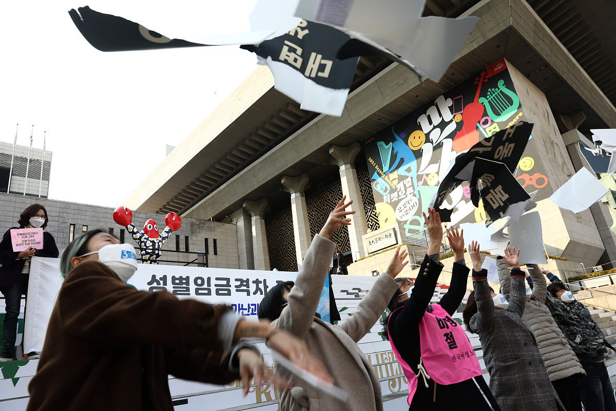 当地时间2021年3月8日,韩国首尔,民众在街头举起牌子与抗议标语,反对