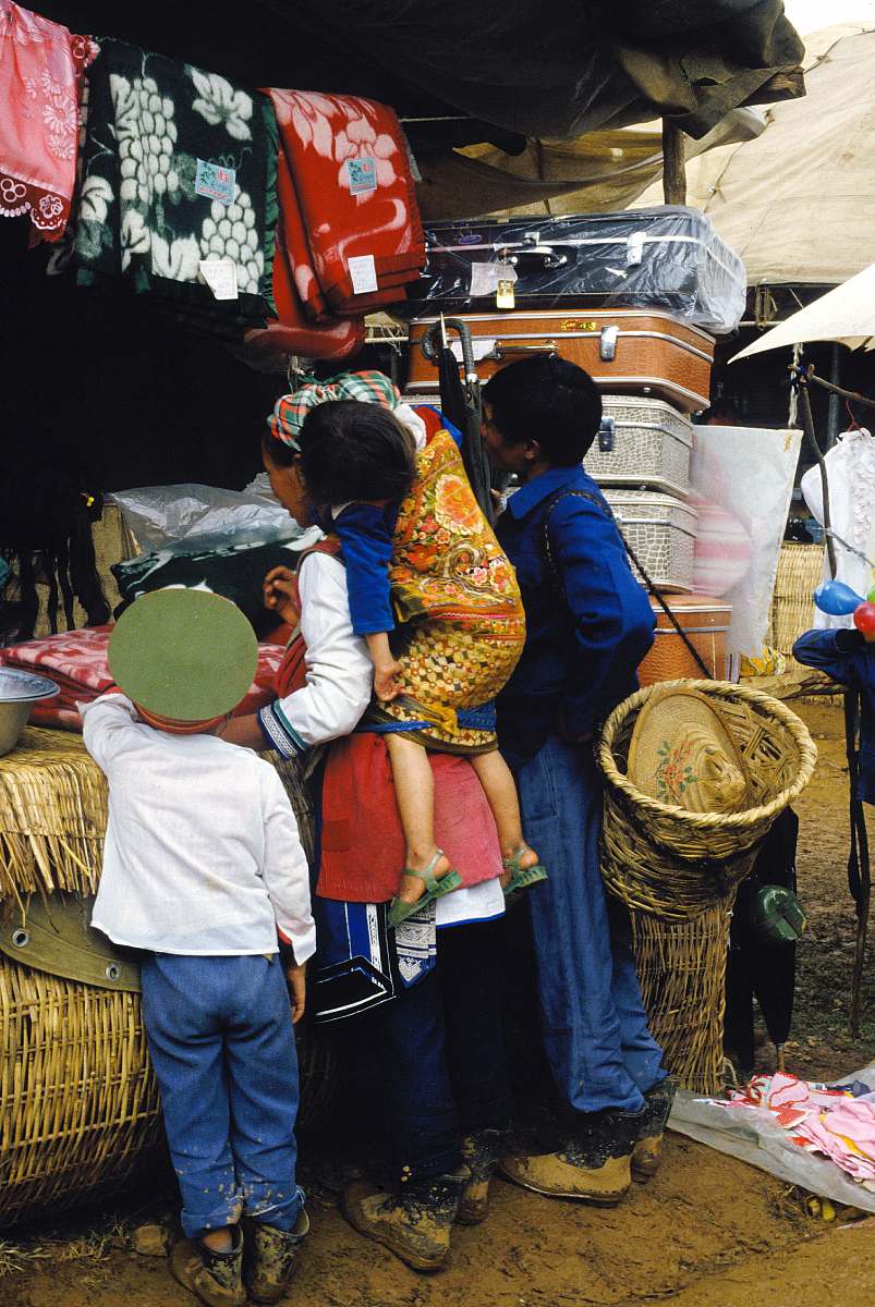 1987年10月,云南省大理市,白族三月节集市上卖纺织品和行李箱的摊位.c