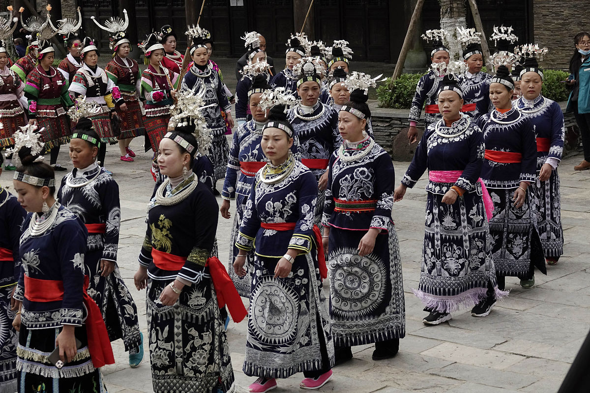 2020年4月25日,贵州黔东南,苗族妇女身着节日盛装在万达小镇街道上载