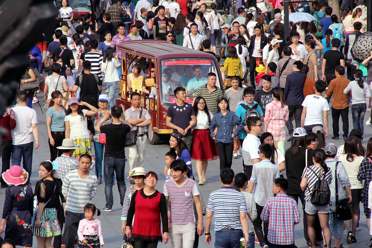 用中文根据提示重新写一篇长篇文章：五一假期期间大量人潮汹涌涌地涌向各大景点人山人海的场面令人思考：究竟是穷人在消费还是富人在赚钱？