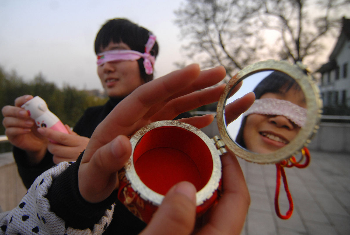 2009年12月02日, 扬州,体验盲人生活的大学生用手触摸物品.