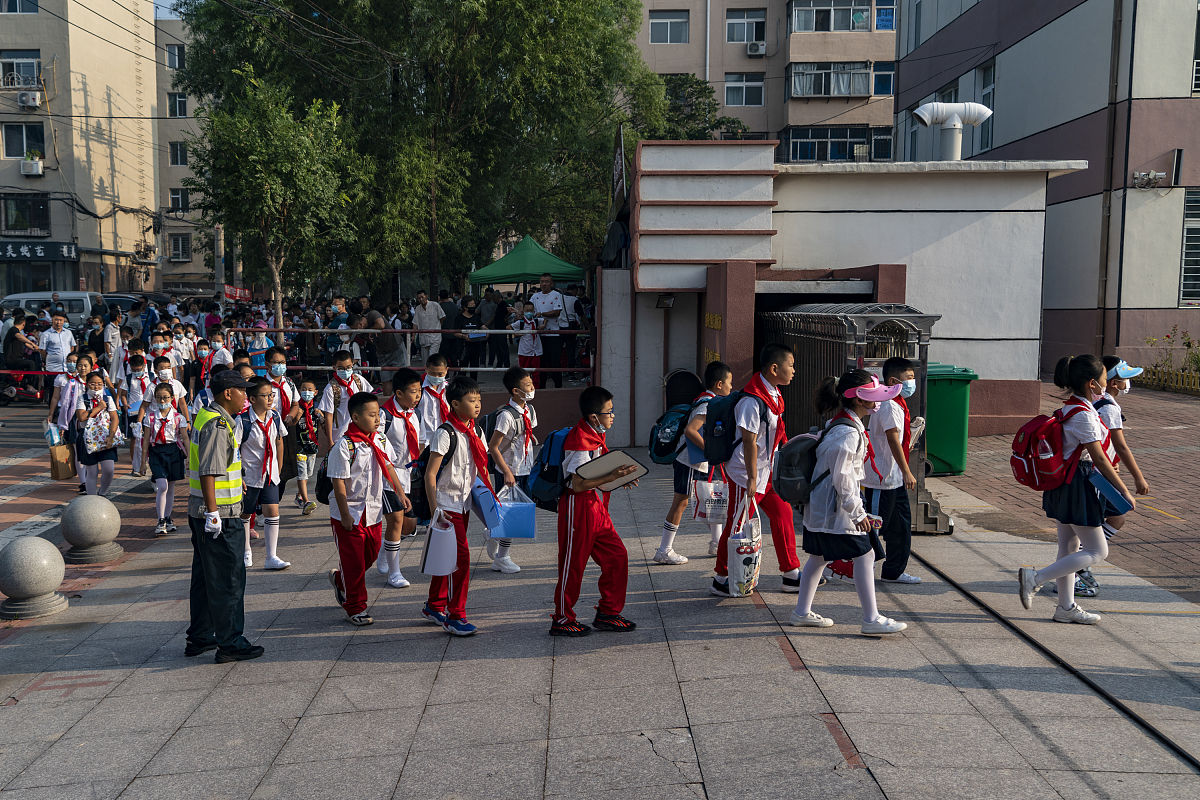 2021年9月1日,辽宁锦州,解放小学的学生们佩戴口罩,在校门外自觉排队,