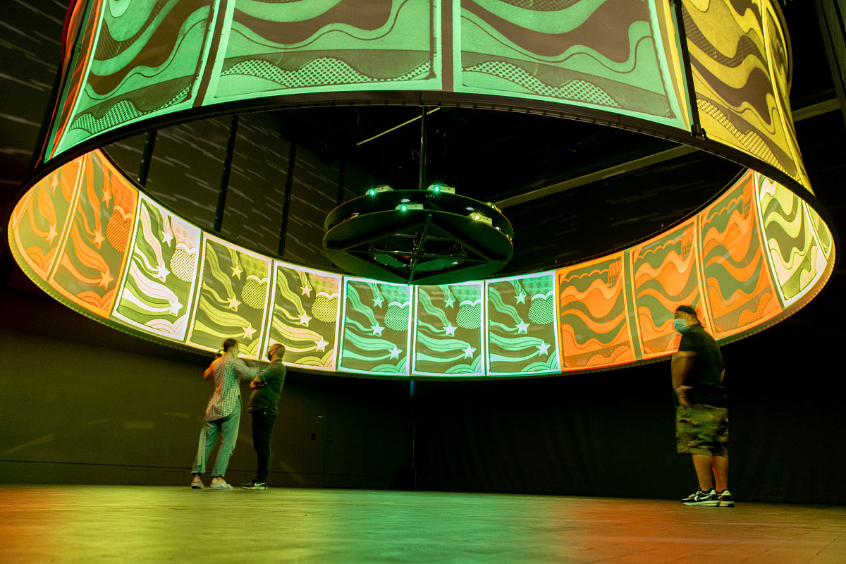 帮我把在未来世界人们都带着氧气面罩大人带着小男孩在博物馆里看到了之前美丽的地球翻译成英文