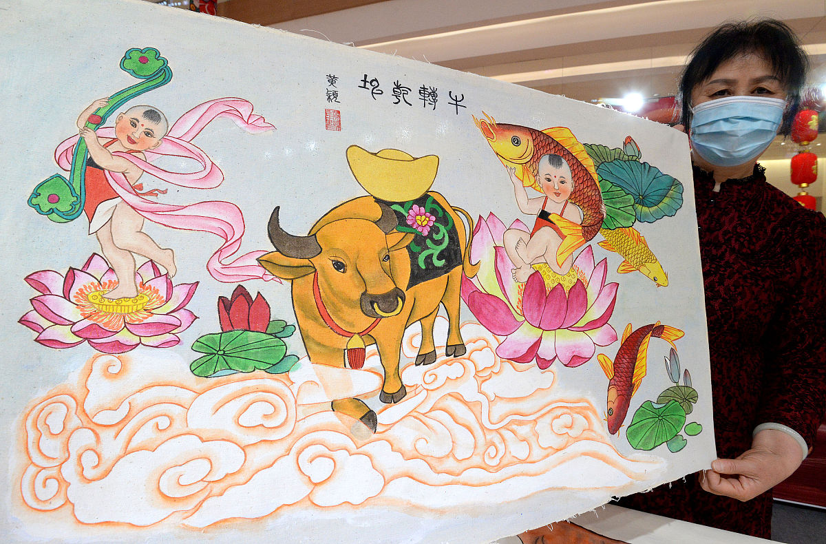 2021年2月24日,河北邯郸,一位民间艺人展示牛年主题手绘年画.