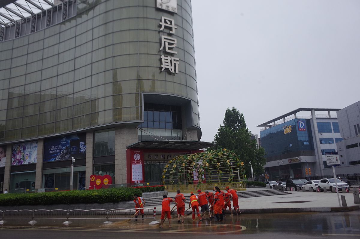 2021年7月23日,河南省会郑州雨停,清洁工清扫积水.