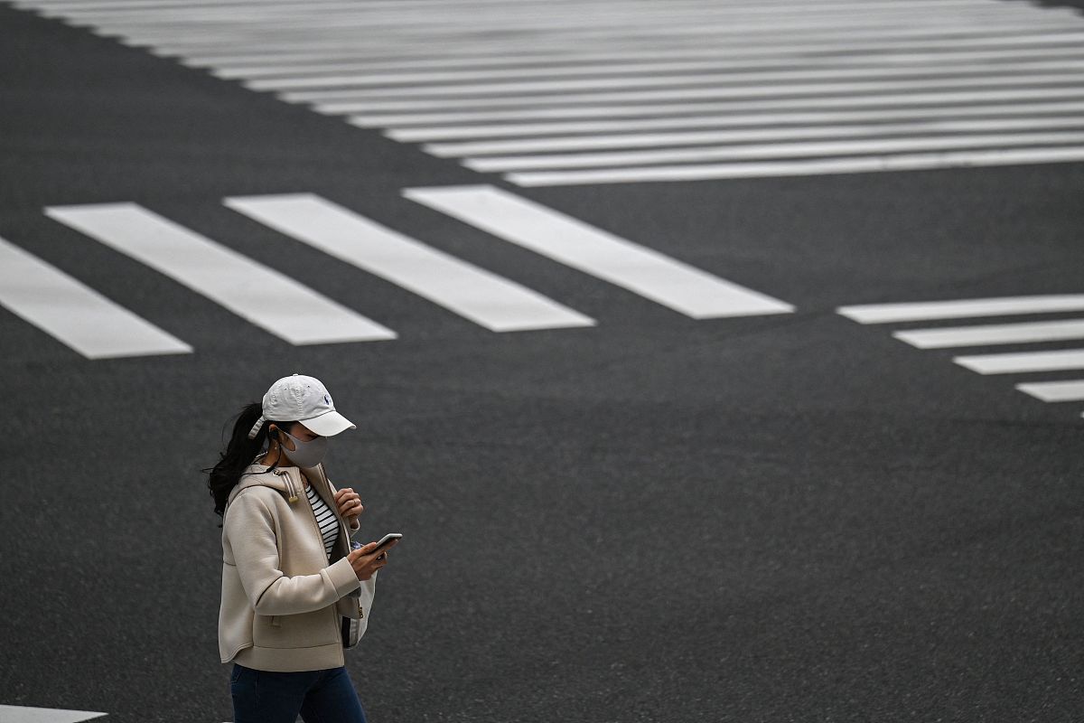 <strong>a</strong> woman crosses a street in tokyo