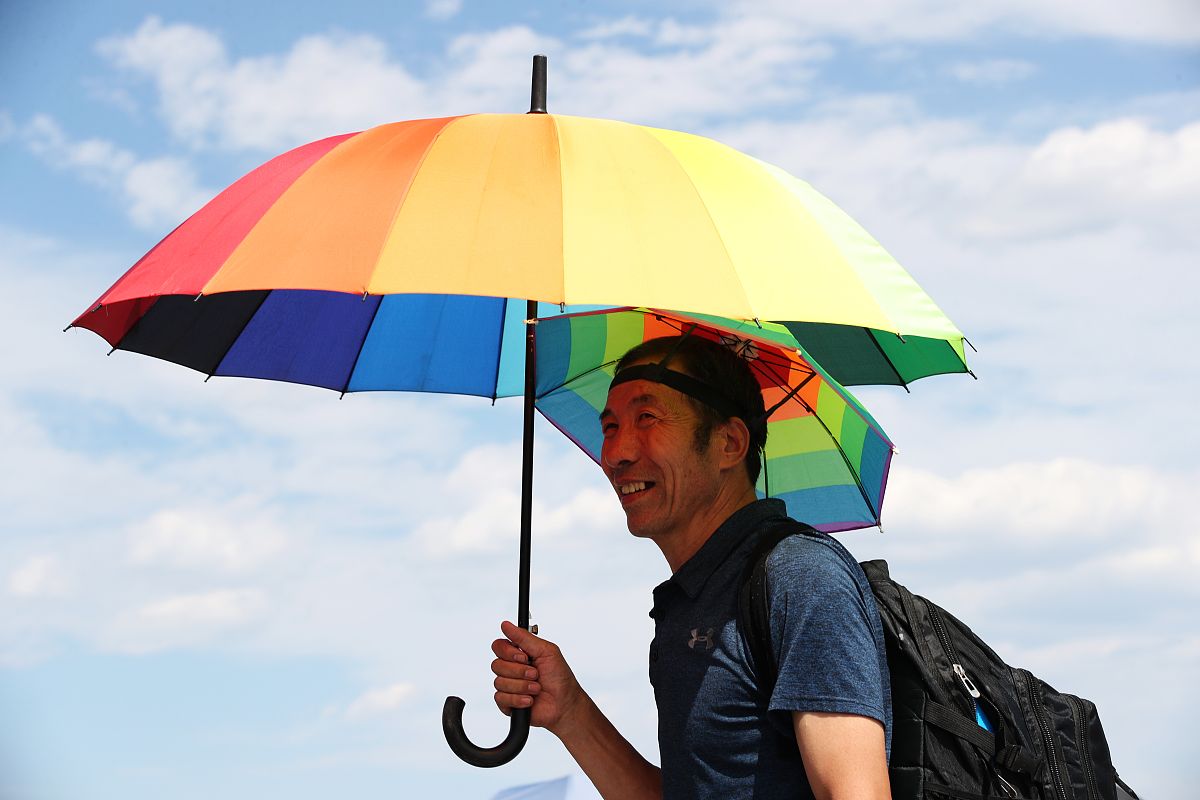 2021年06月20日,北京,游客顶烈日游览天安门广场,并采取各种方式遮阳
