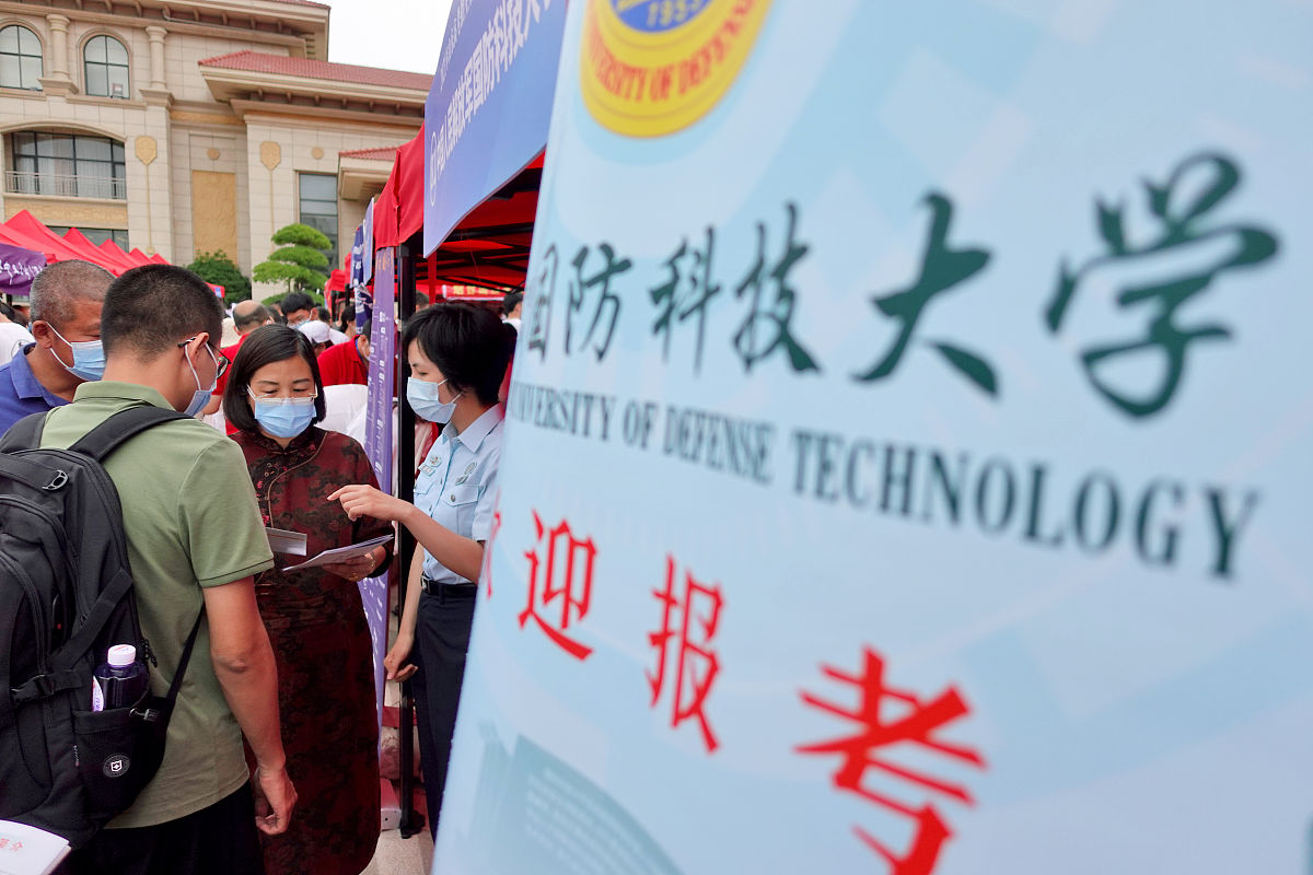 2021年6月27日,在山东烟台鲁东大学,军校招生人员(右一)向考生和家长