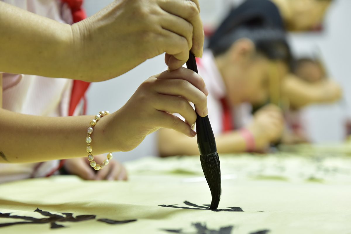 2020年8月9日,书法家杨兴玲在手把手教合肥市十里庙小学书画社团的小