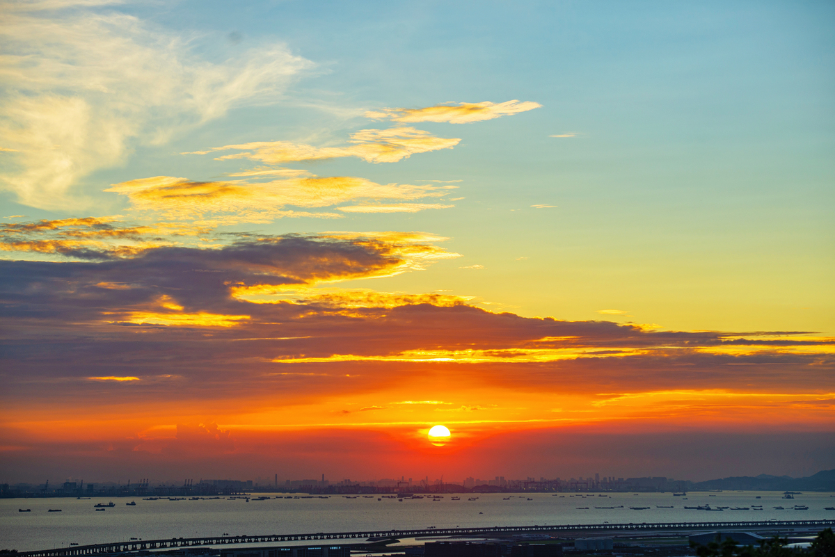 用文艺一点的文字表述一张在深圳湾公园拍摄的落日的照片