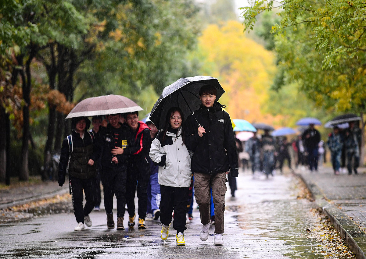2020年10月21日,受冷空气影响,沈阳降雨降温,行人冒雨出行.时下正是沈