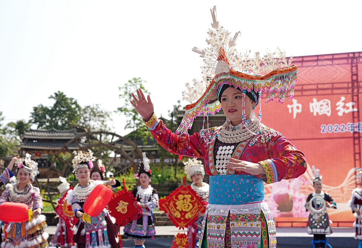 2022年3月7日,在广西柳州市融水苗族自治县梦呜苗寨,一名女职工在展示