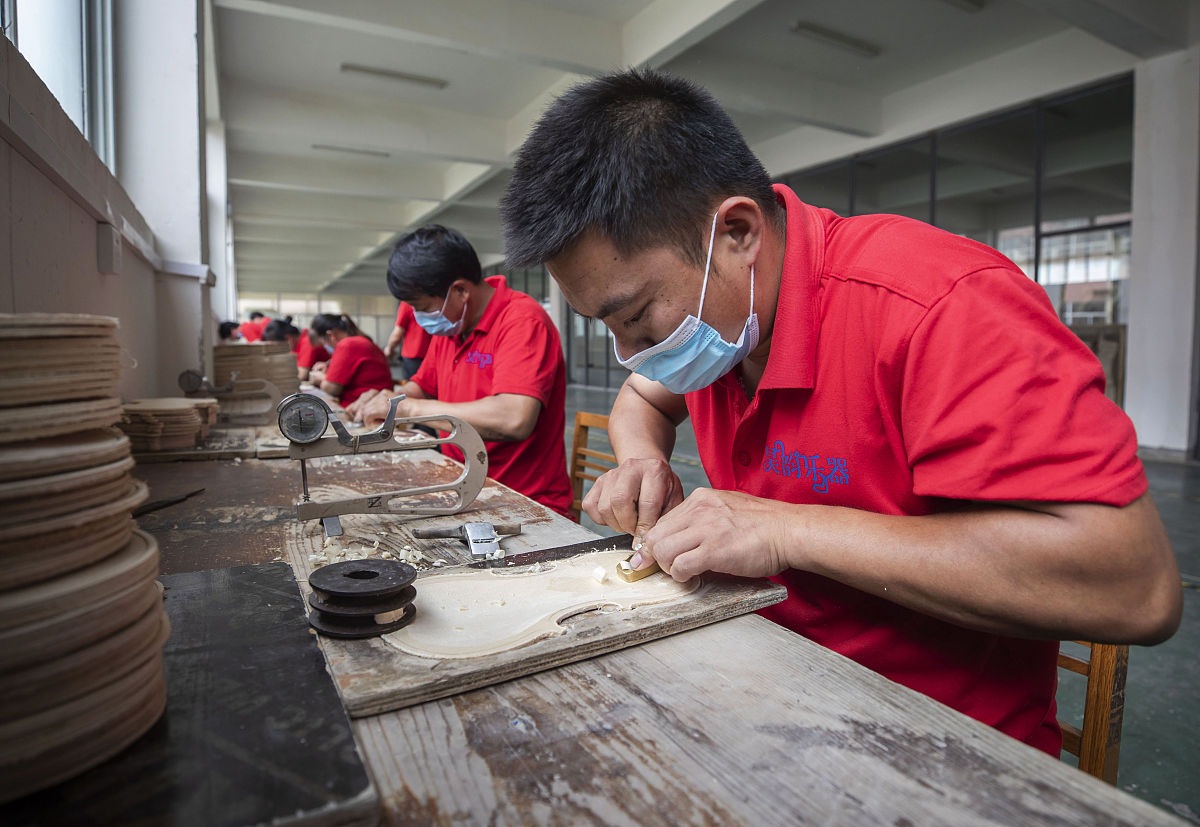 2020年6月14日,河南驻马店,在确山县提琴产业园内,工人们正在制作各种