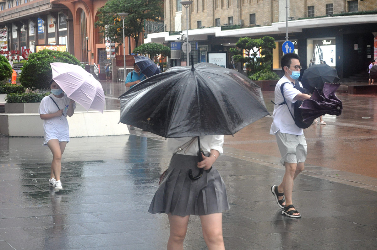 2021年7月25日,受台风"烟花"影响,上海风雨交加,南京路步行街市民游客