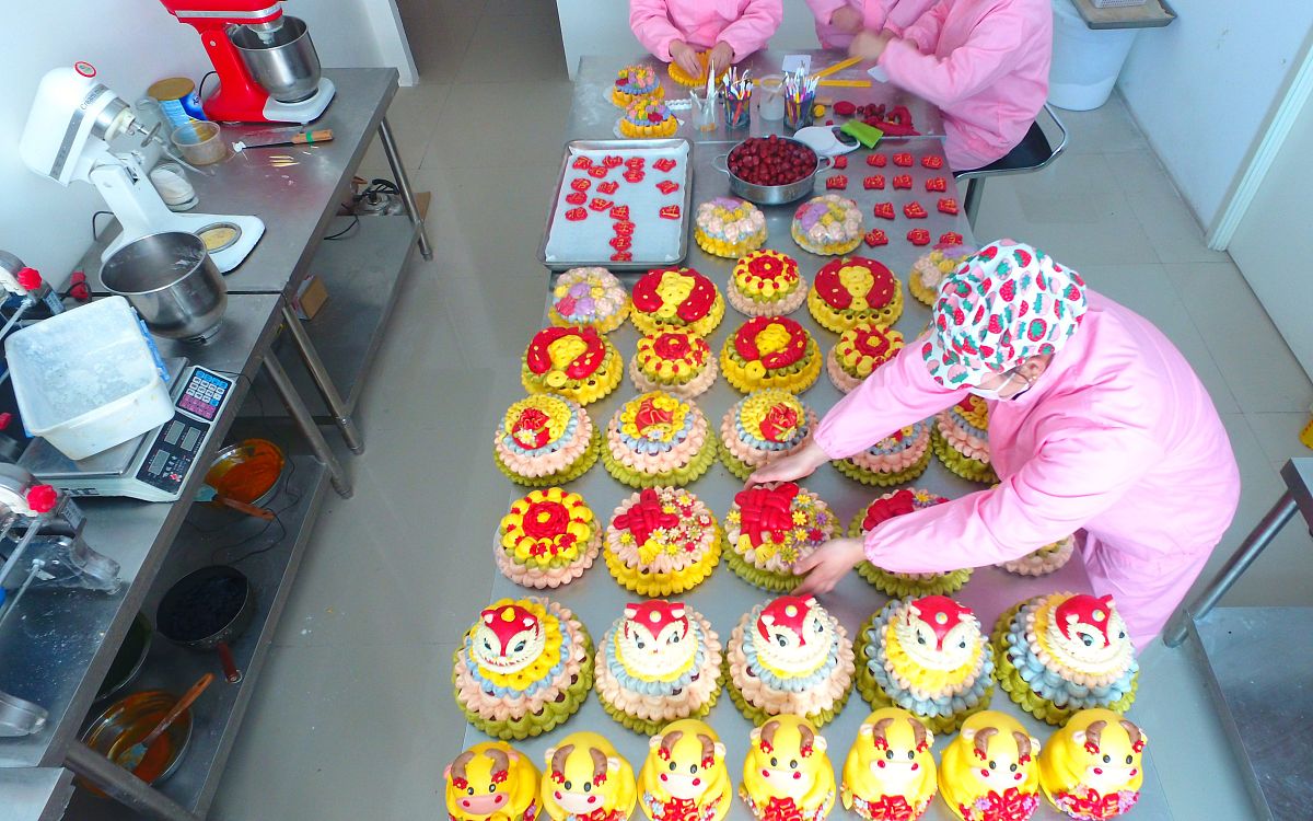 2021年1月18日,山东聊城,在茌平区一家花糕制作店,工人在忙着加工制作