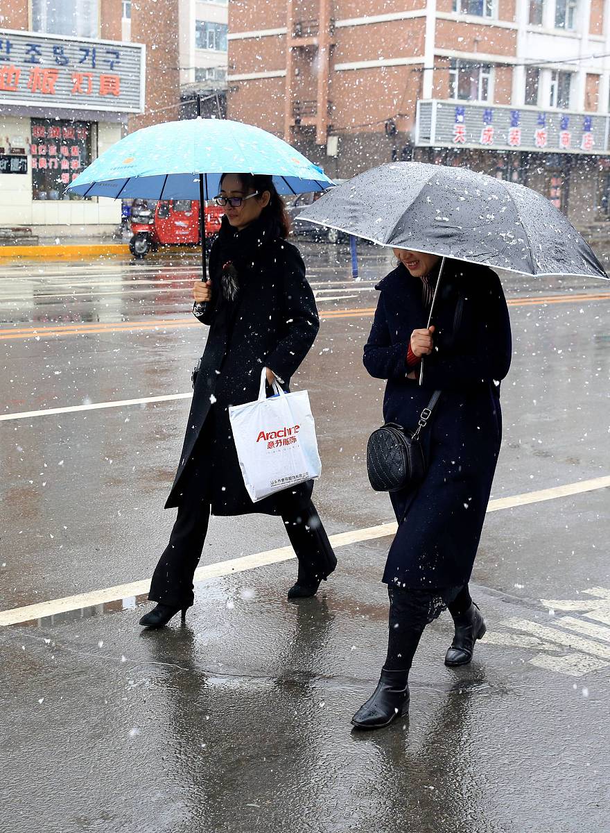 2019年3月21日,行人在吉林延边安图县城冒雪出行.