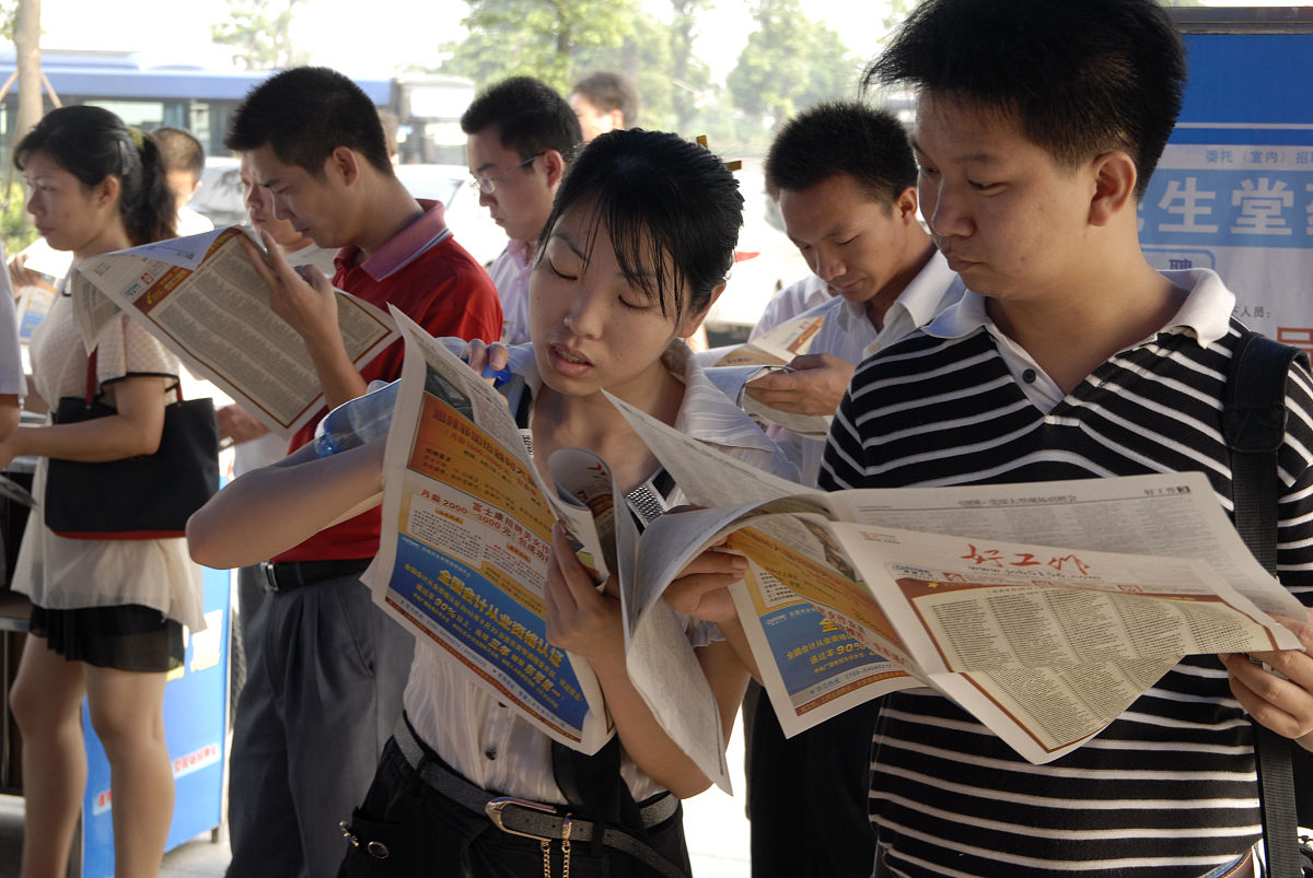 2010年08月28日,广东省东莞市.在人才市场看招聘广告的打工者