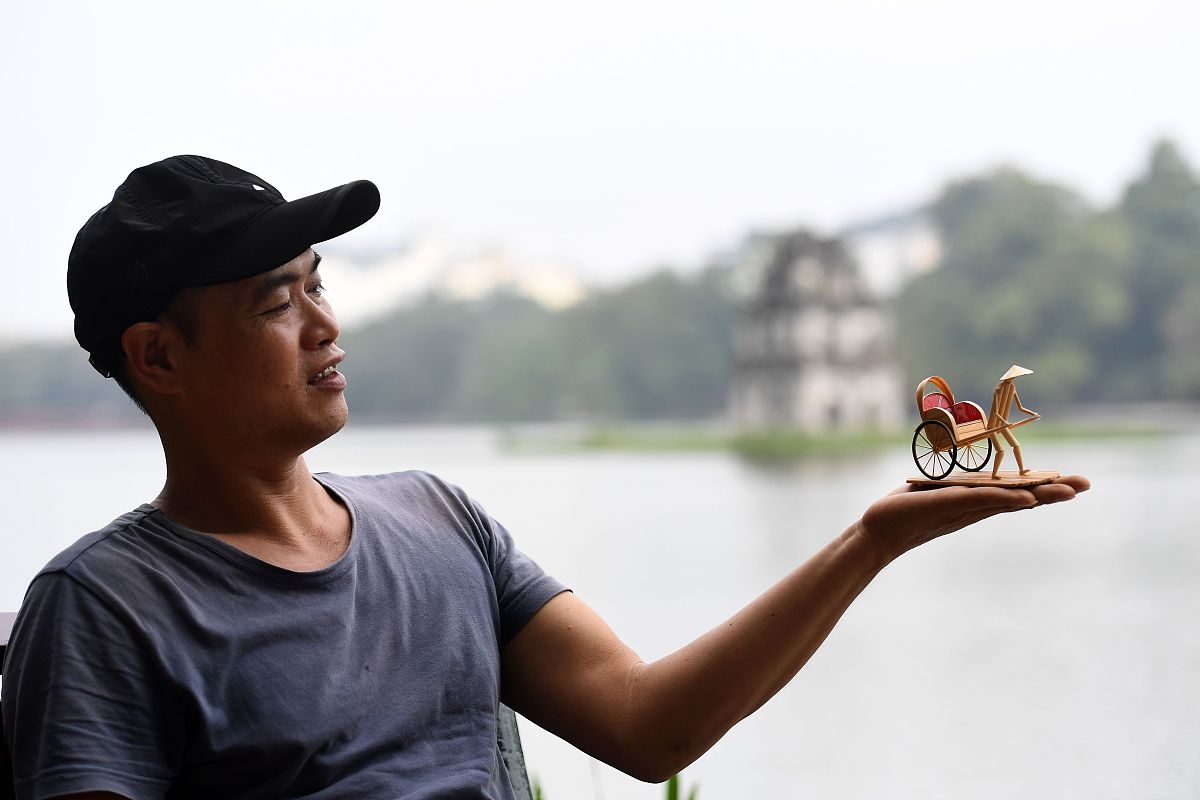 当地时间2020年11月25日,越南河内,一名越南男子展示他制作的微缩竹雕