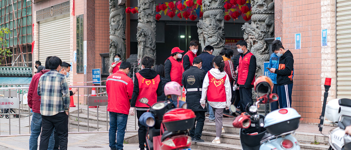 2022年1月18日,广东梅州,在五华县工业园区门口志愿者组织群众排队进