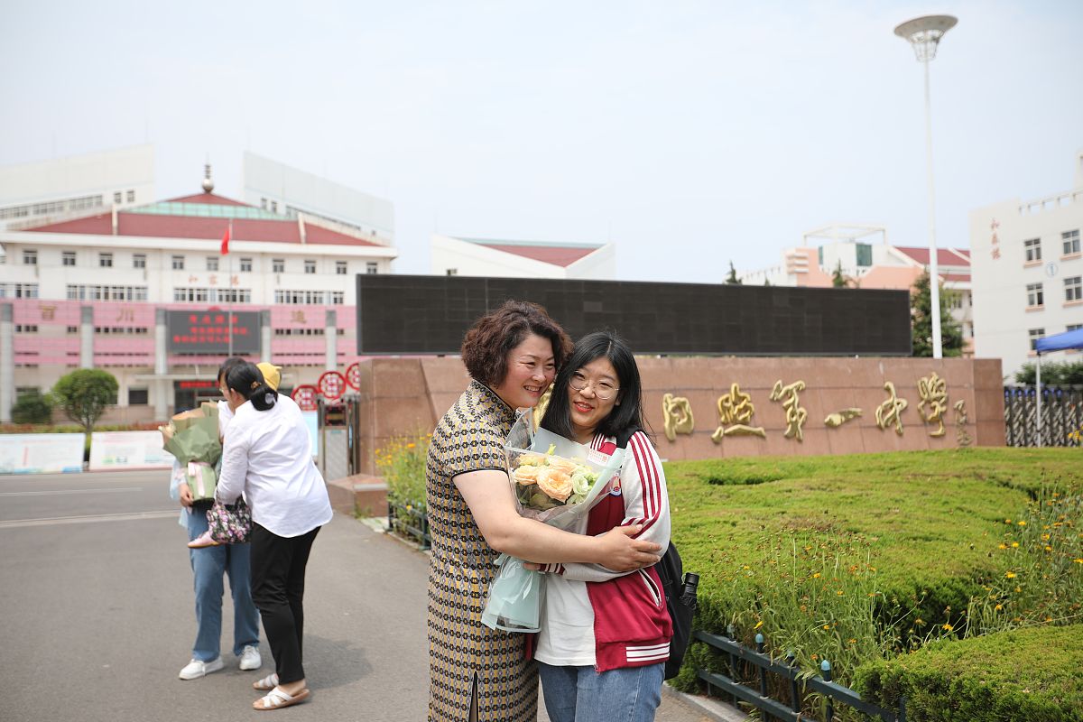 2021年6月10日,在山东日照市第一中学校区考点外,考生和家长拥抱.当日