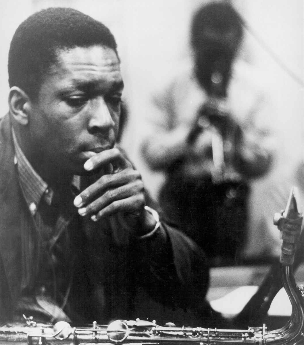 circa 1961:  jazz saxophonist john coltrane listens as a man pla