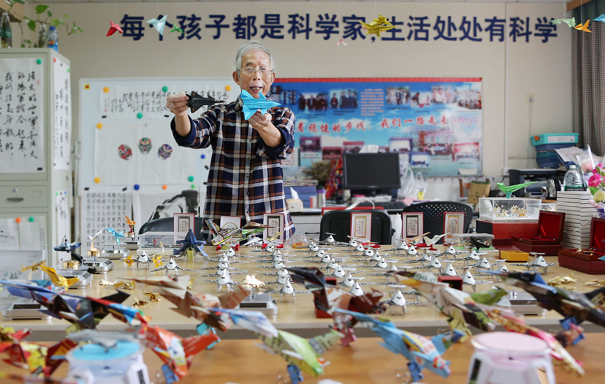 2019年9月15日,成都,许树全通过观摩飞机模型来折纸飞机.许树全是成飞