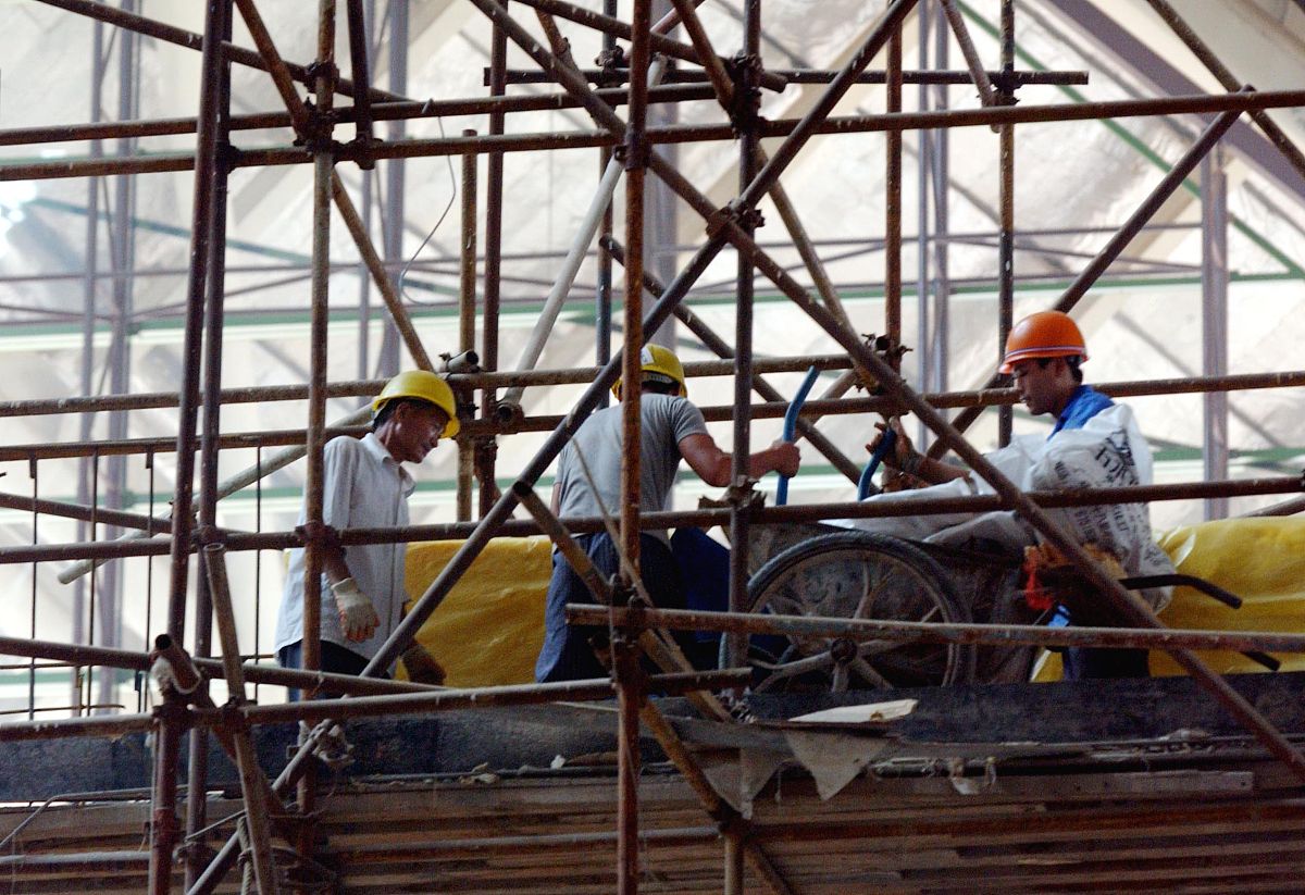 2005年7月8日,郑州市郑东新区的会展中心里,一建筑农民工正在紧张施工