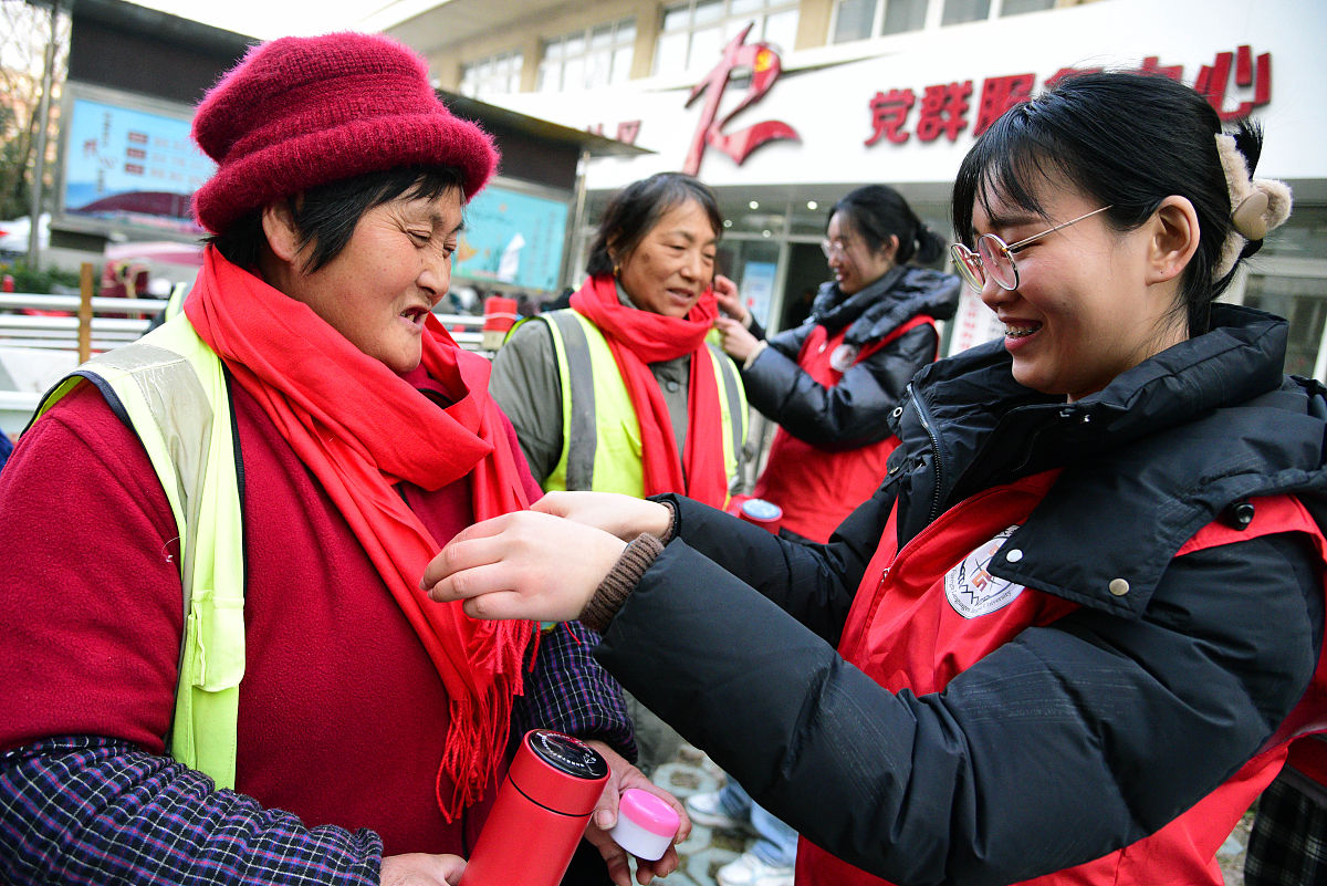 2022年1月13日,在江苏省镇江市新城社区,江苏大学志愿者在向环卫工人