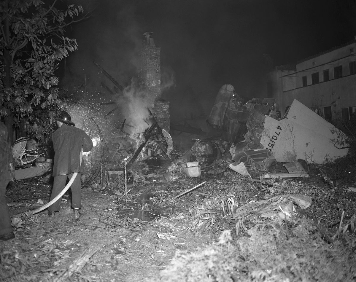 fireman attempts to extinguish flames from the wreckage of howar