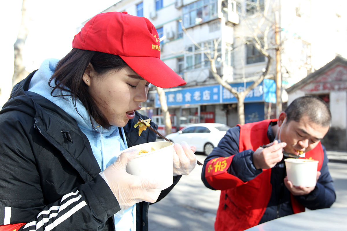 2021年1月9日,石家庄,志愿者在冷风中吃午饭.