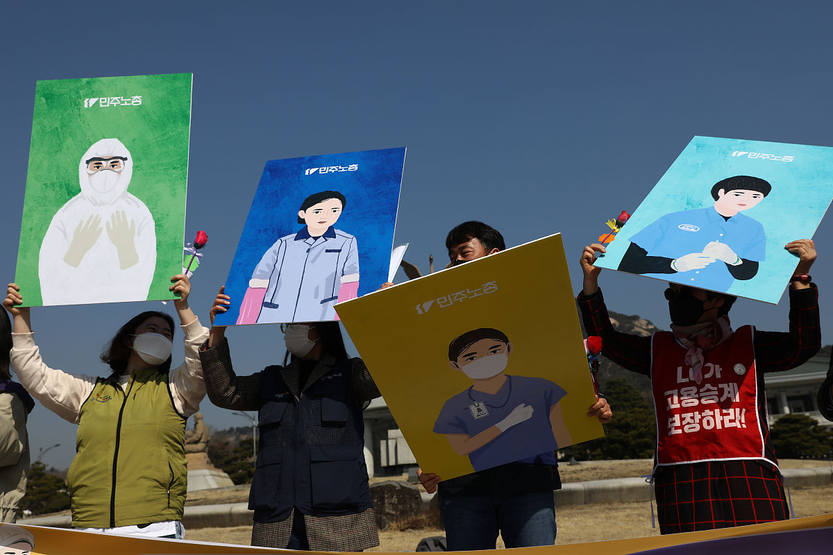当地时间2021年3月8日,韩国首尔,民众在街头举起牌子与抗议标语,反对