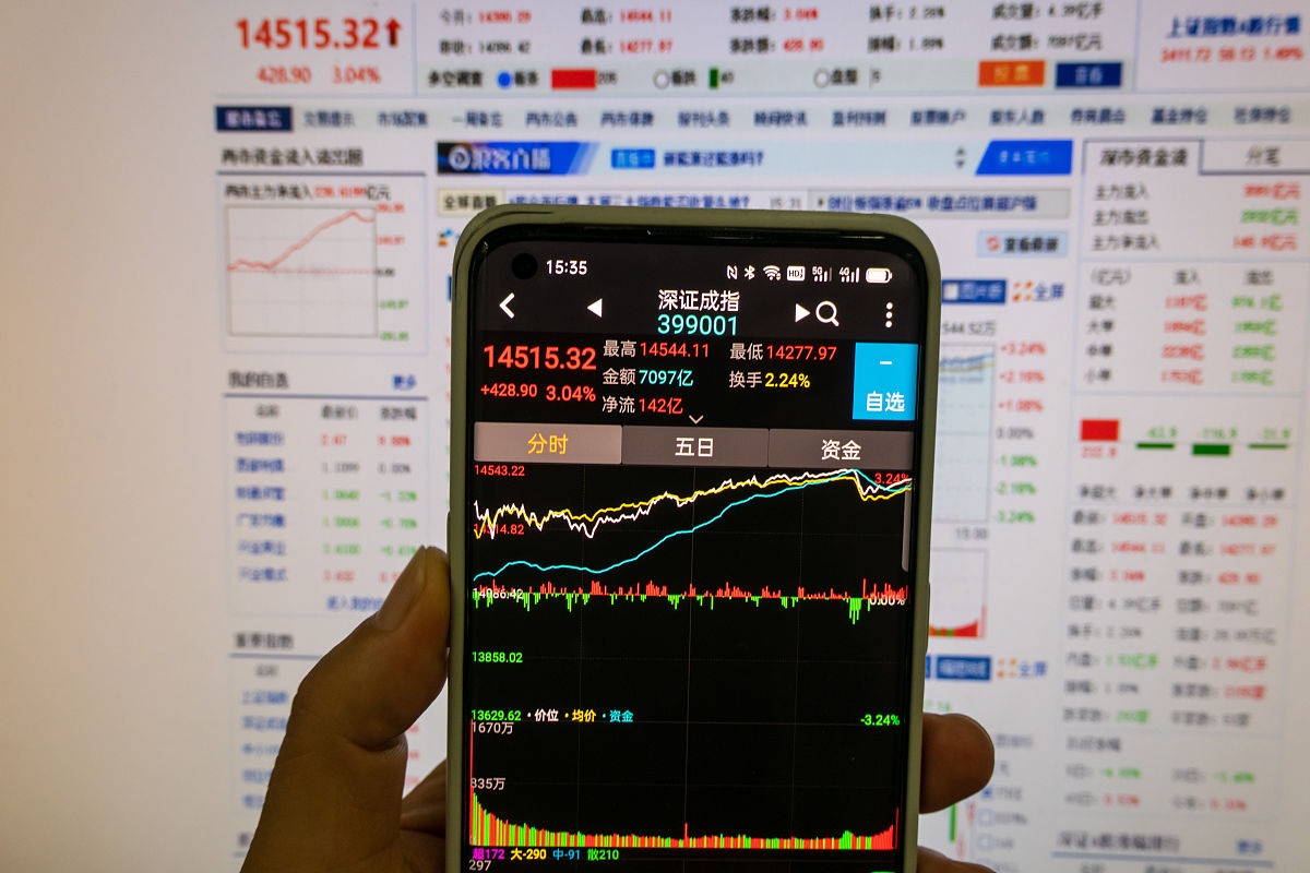 2021年7月29日,上海,下午收盘后,股民通过手机和电脑查看当天股市收盘