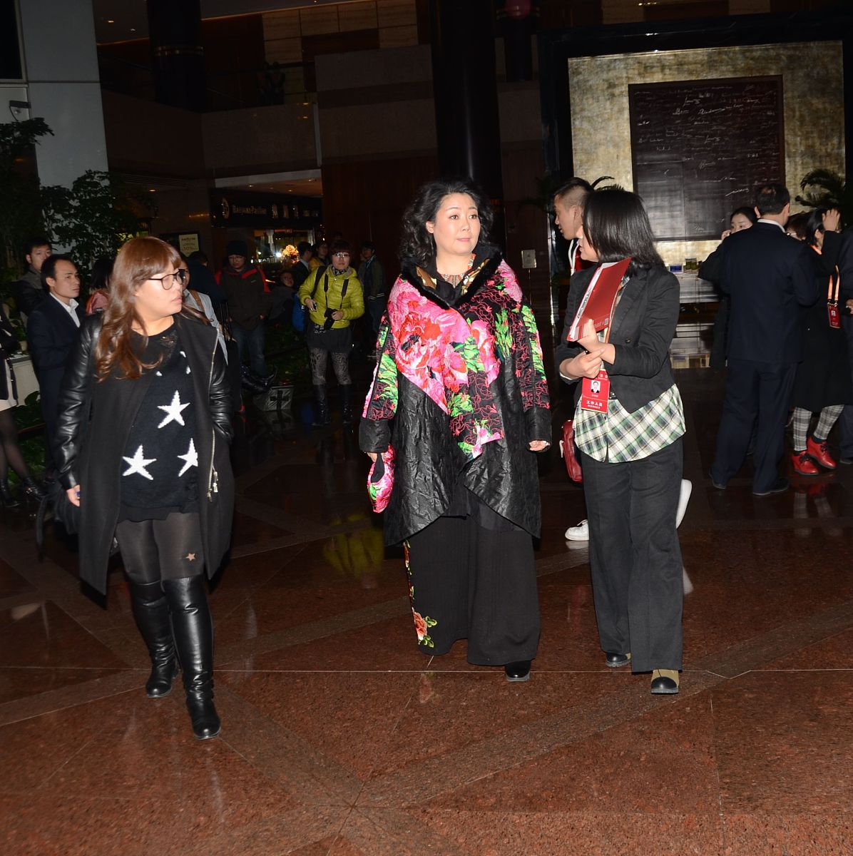 请描写一下一个老婆婆带着1一个年轻人和一个小孩儿在神社参拜一个女巫的画面