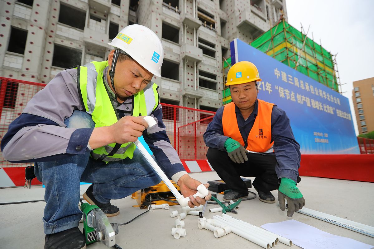 2021年4月30日,在天津市保税区空港云栖路项目现场,项目一线工人开展"