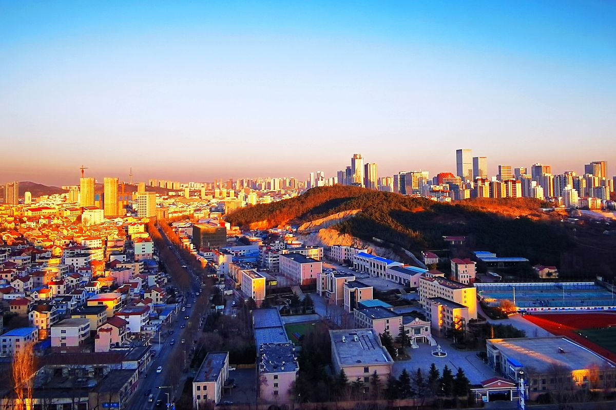 2021年12月27日,山东青岛,夕阳余晖呈现出一片暖金色,将西海岸城区装