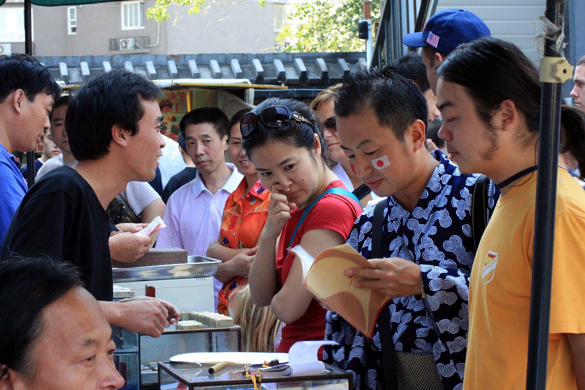 2008年北京奥运会期间,观赛的外国游客和各国运动员在比赛间隙慕名来