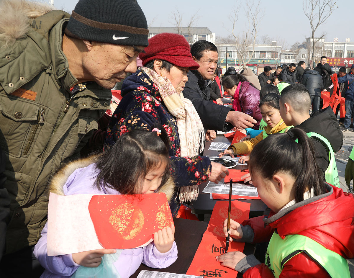 2018年2月7日,江苏徐州,青少年"书法家"为市民书写春联.