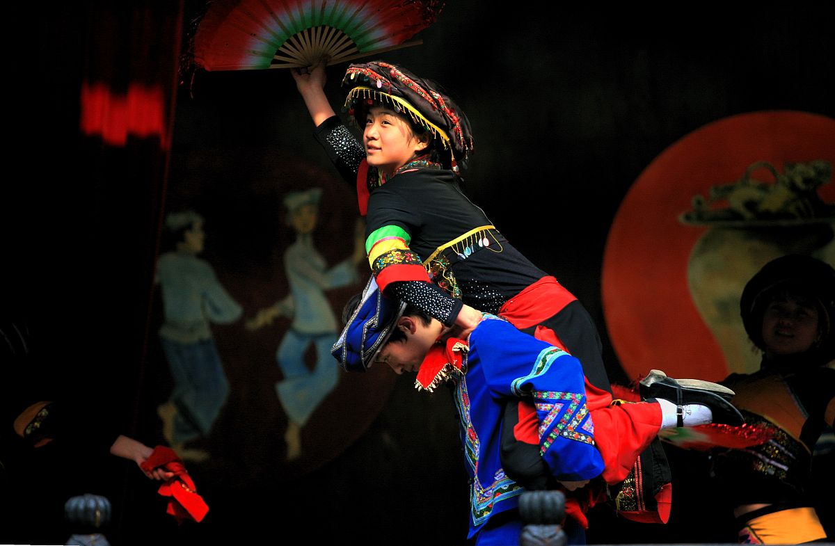2009年12月30日,湖北恩施州土司城景点的土家族,苗族青年为游客表演民