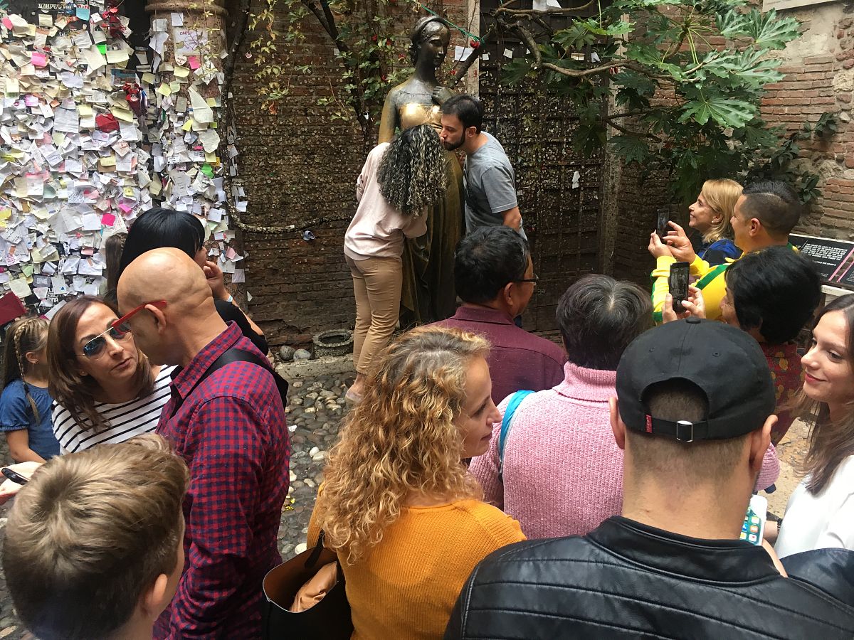 当地时间2018年10月17日,意大利维罗纳,游客在朱丽叶铜像前合影留念时