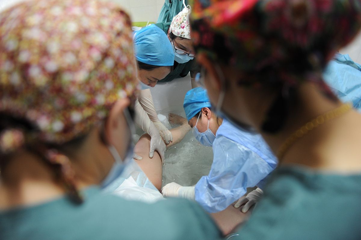 快要临盆的女医生再逛商场的时候看到一个孕妇突然羊水破了生孩子女医生为这名孕妇接生的过程中自己的羊水破了女医生也要生了两个人一起生孩子。写小说。3000字