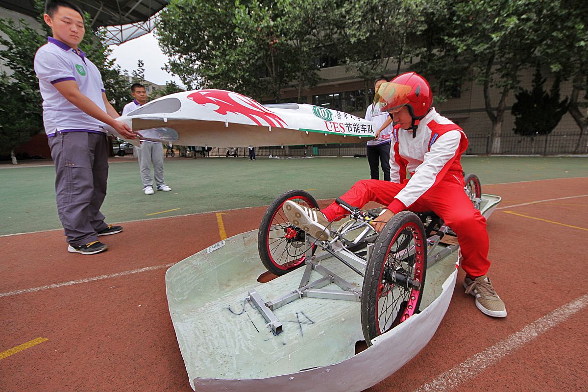 2014年09月16日,在山东烟台鲁东大学,试车手正费力地坐进驾驶座.