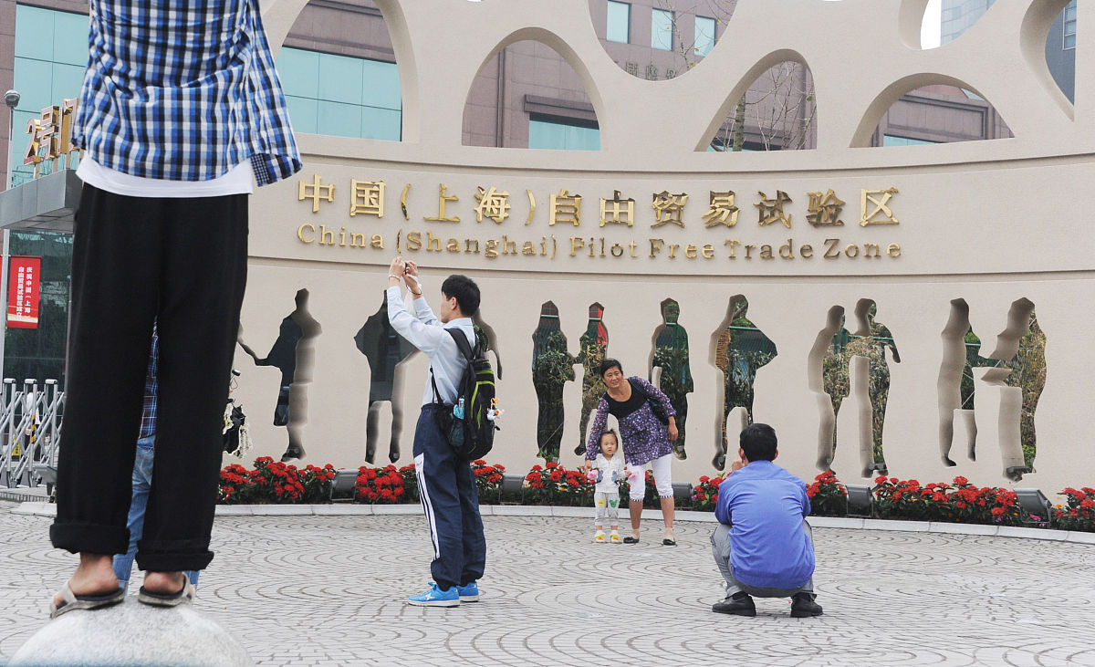 2013年10月2日,上海,市民游客在自贸区的牌子前合影留念.