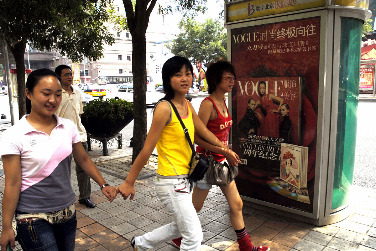 2006年8月27日,北京,时尚广告前的行人.hip young chinese walk by a 