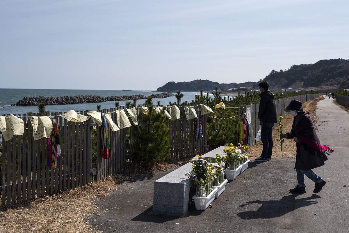 当地时间2021年3月11日,日本久之滨,民众和僧侣前往海边悼念遇难者,纪