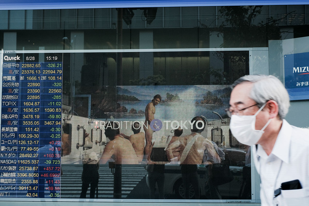当地时间2020年8月28日,日本东京,证券公司外的股票信息.a pedestrian