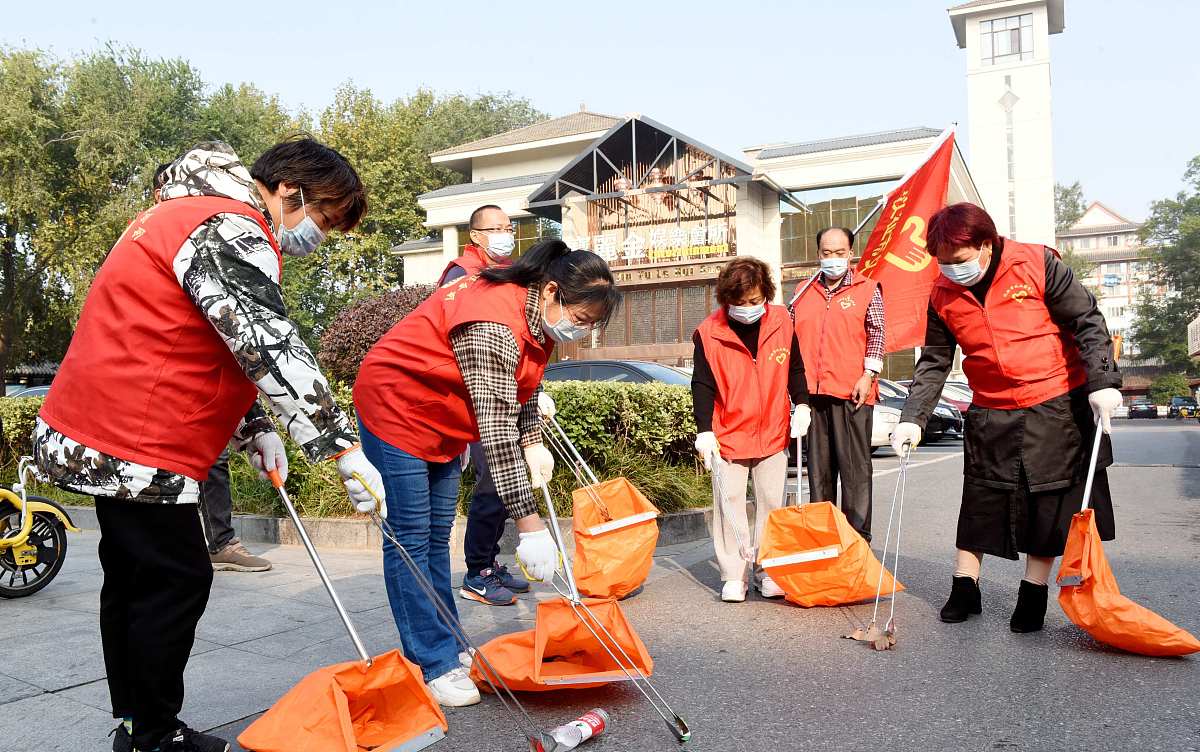 2021年10月27日,江苏扬州,仪征市中原贸城街头,一群志愿者正在道路两