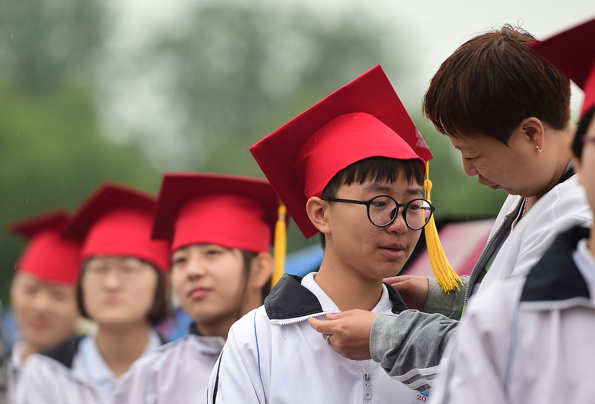 2018年5月21日,河北沧州,泊头市第一中学成人礼现场,家长为孩子佩戴成