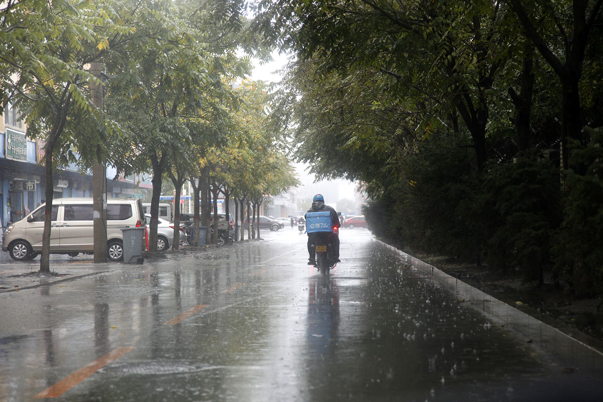 2020年9月7日,吉林延边州图们市,一位骑摩托车的外卖小哥冒雨送餐.