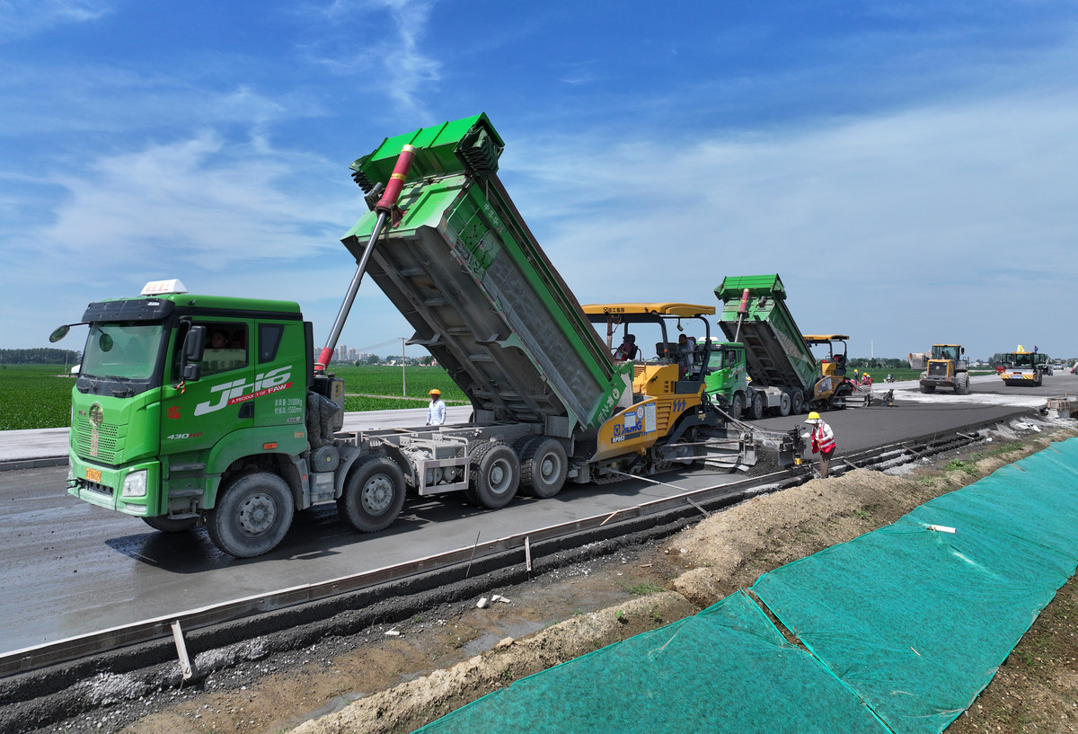 请用自己的语言重新表述下面文本调整文本表达及结构不要改变最终文本意思：SMA-13S混合料运输采用10台自卸车。运输车辆在开工前要检验其完好情况装料前应将车厢清洗干净尽快将拌成的混合料运送到铺筑现场。车上的混合料采用篷布覆盖在卸料前不得收起以减少水分损失。运料车将混合料运至施工现场时在距离摊铺机较远的非工作区安排专人指挥调头慢速后倒行驶至摊铺机前防止在工作区内调头、刹车破坏下承层表面